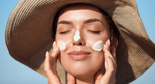 Primo piano di una donna che si spalma la crema solare sul viso