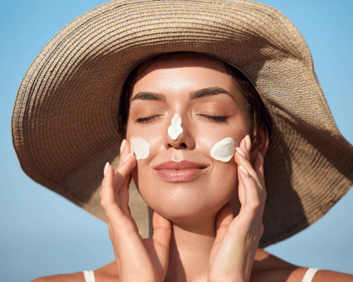 Protezione della pelle Primo piano di una donna che si spalma la crema solare sul viso
